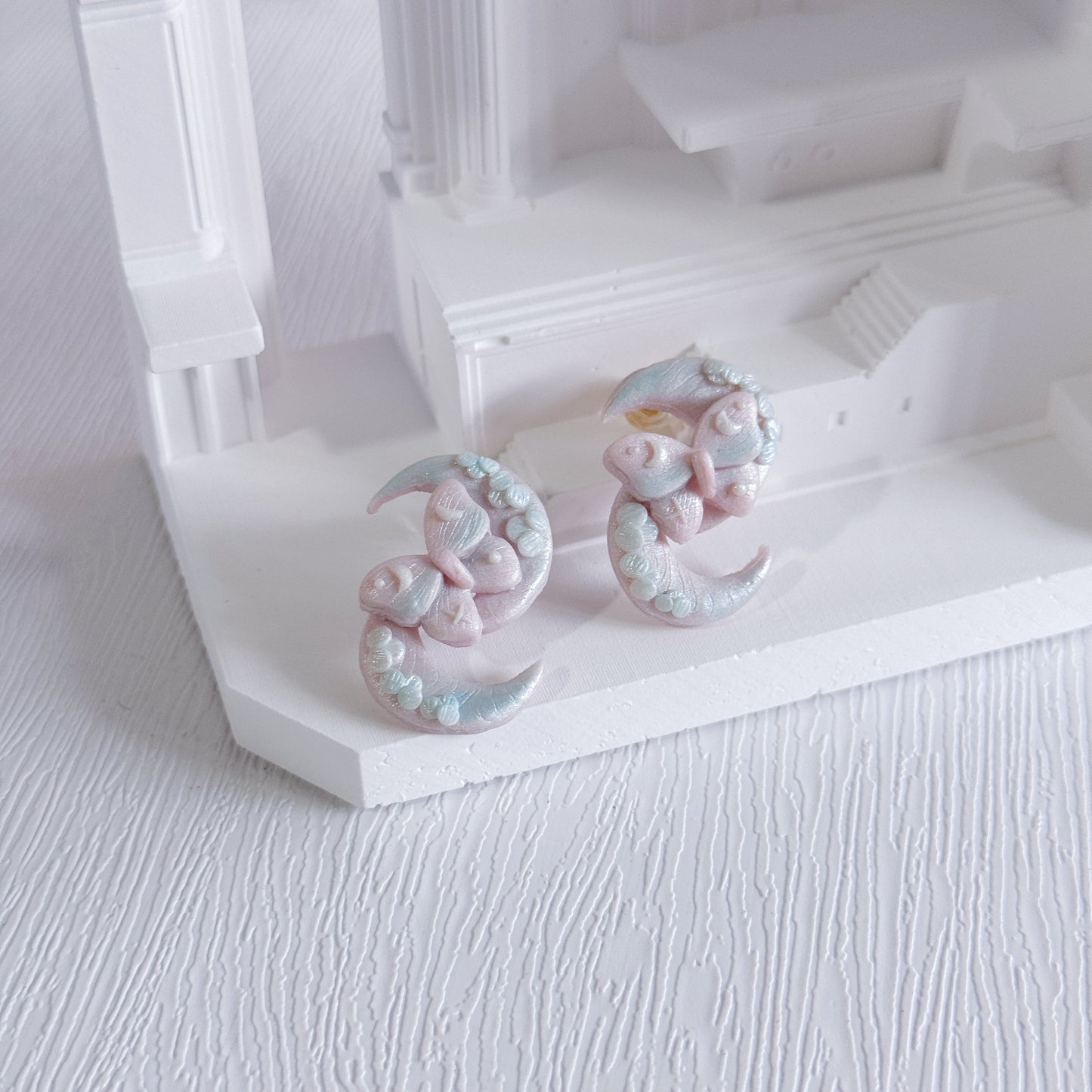 Decorative earrings on a white stand with a white background