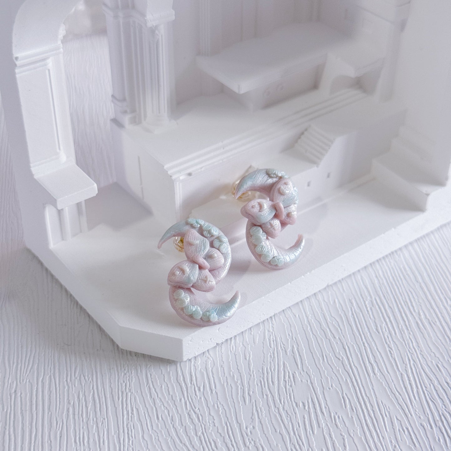 Pair of earrings on a white architectural model
