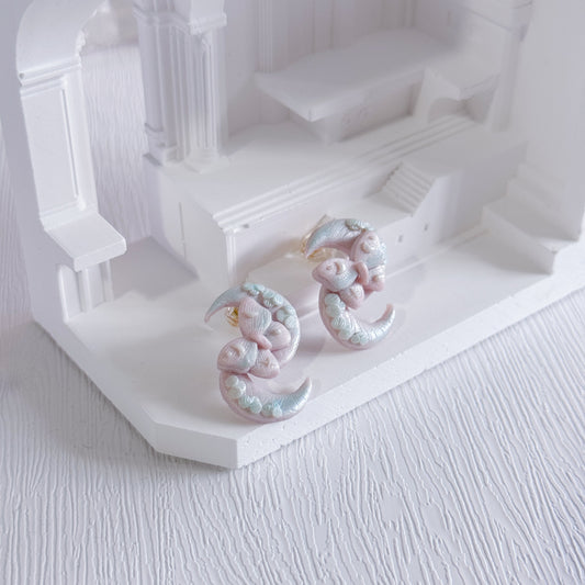 Pair of earrings on a white architectural model