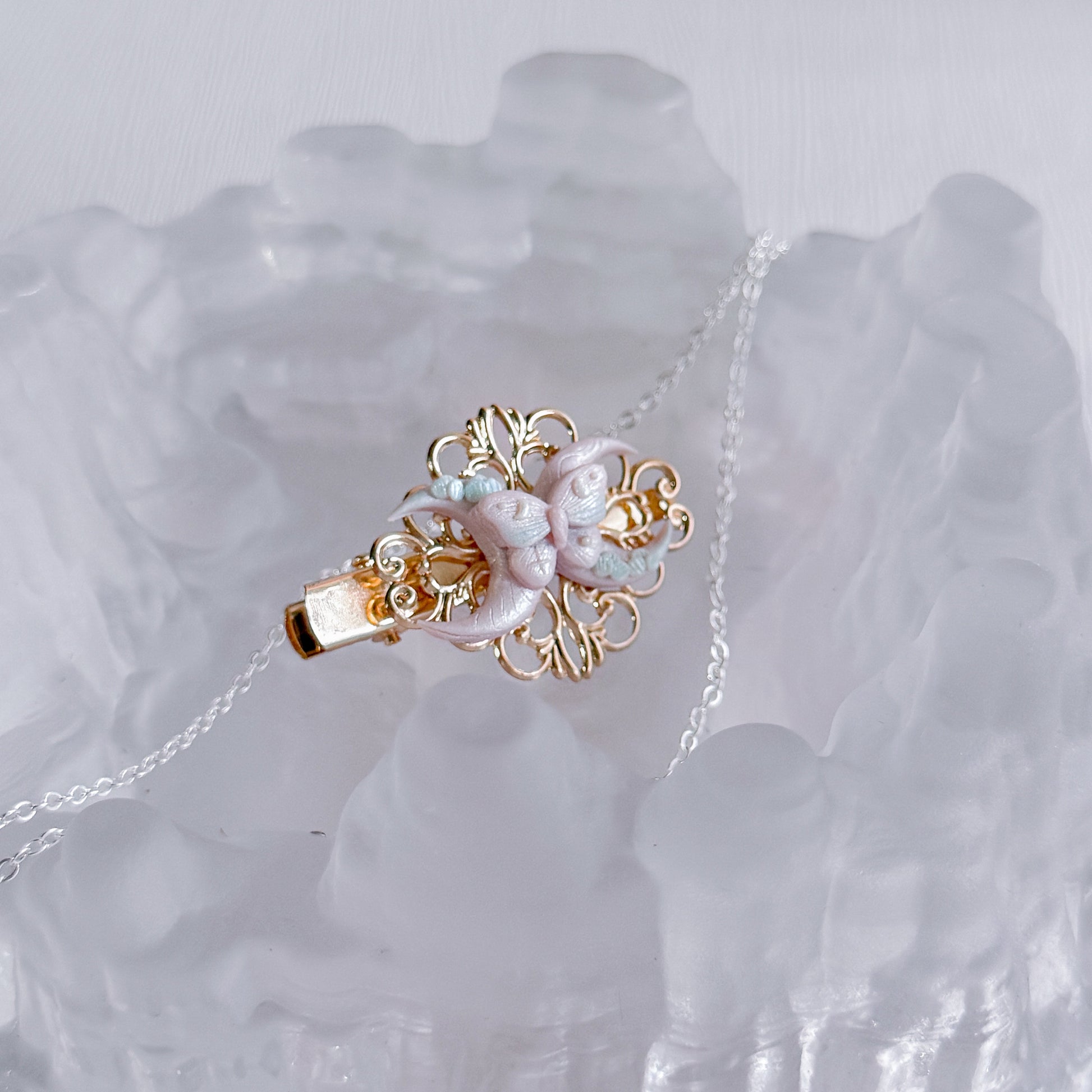 Delicate hair clip with floral pendant on a crystal background