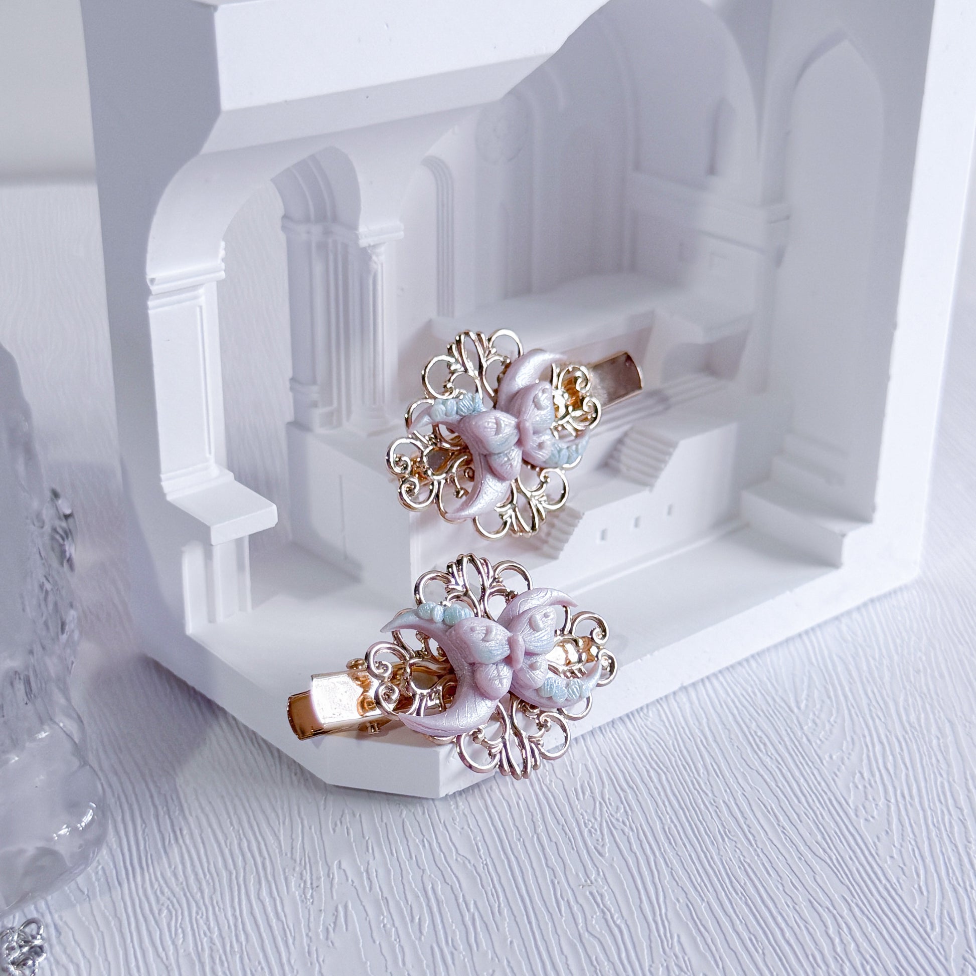 Decorative hair clips with floral design on a white background