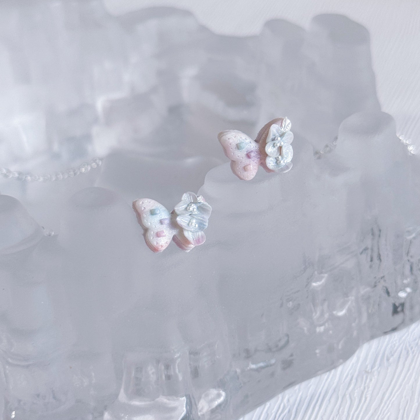 Butterfly-shaped earrings on a clear crystal dish