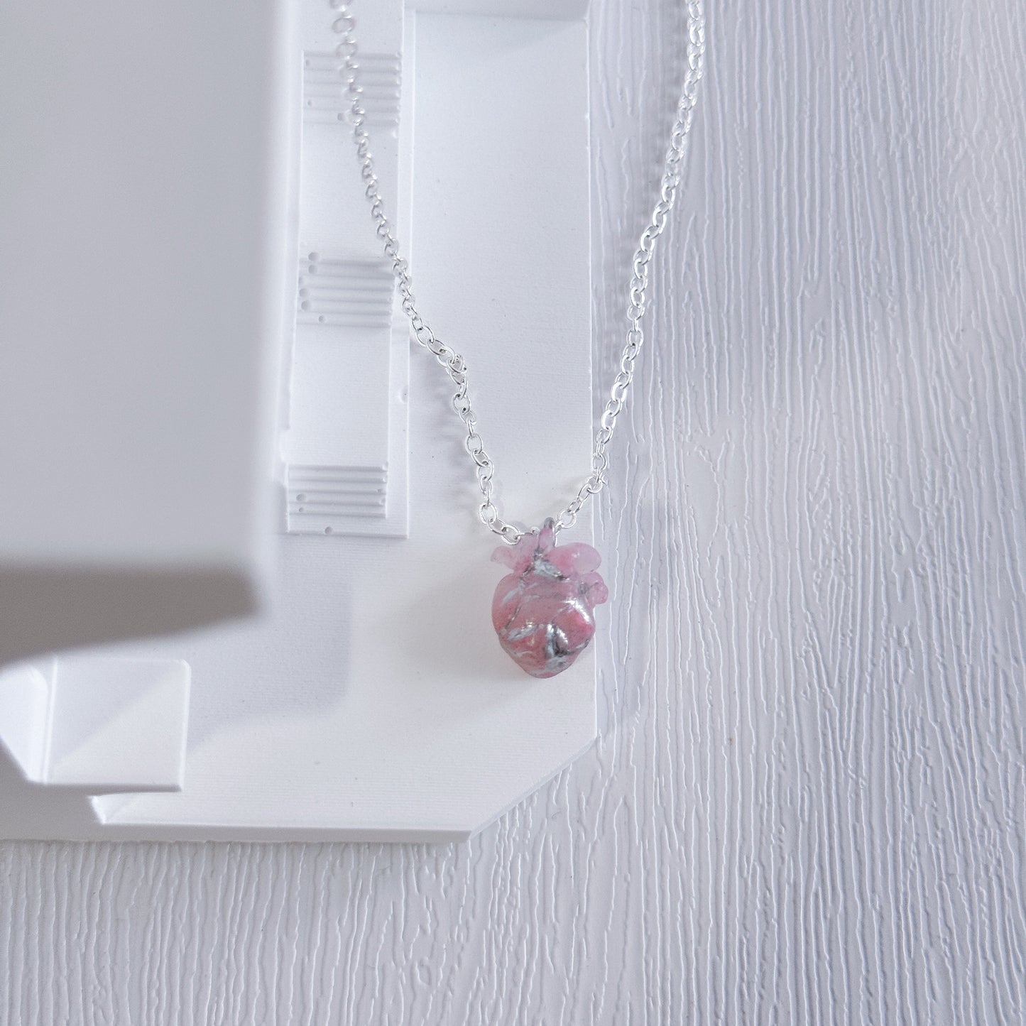 Necklace with a pink heart pendant on a white background